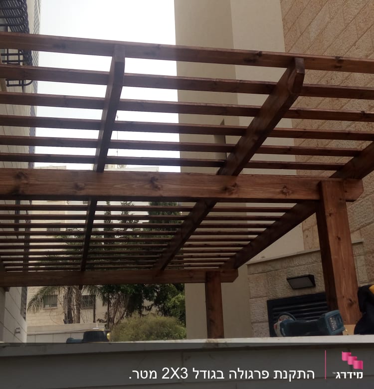 פרגולה מעץ עם כלי עבודה על הקיר